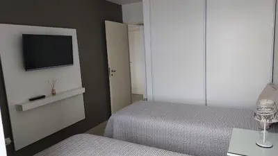 a bedroom with two beds and a tv on the wall at Departamento en Cordoba, Torre Nubis in Cordoba