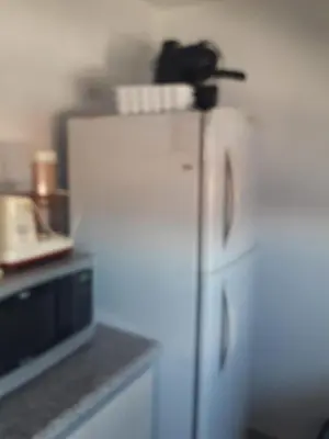 a white refrigerator in a kitchen with a phone on top at Departamento en Cordoba, Torre Nubis in Cordoba