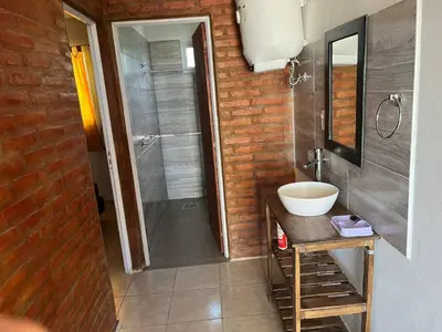a bathroom with a sink and a shower at La casita de Nestor in Cavalango
