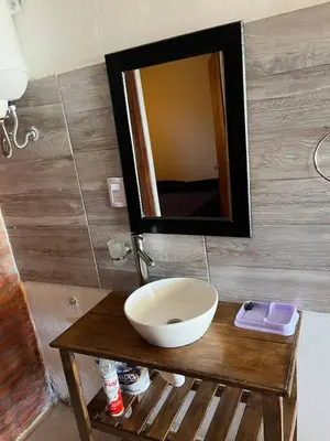 a bathroom with a sink and a mirror on a table at La casita de Nestor in Cavalango