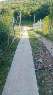 a path leading down a dirt road with a fence at La casita de Nestor in Cavalango