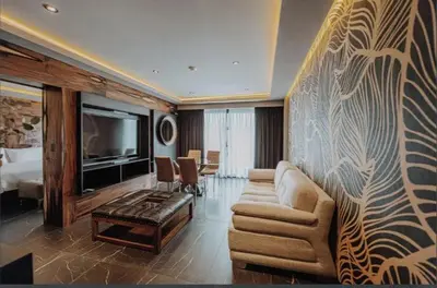 a living room with a couch and a television in a hotel room at La urumpta hotel aken mind in Río Cuarto