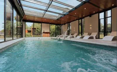 an indoor swimming pool with chairs and a swimming pool at La urumpta hotel aken mind in Río Cuarto