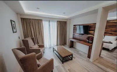 a hotel room with chairs and a desk and a bed at La urumpta hotel aken mind in Río Cuarto