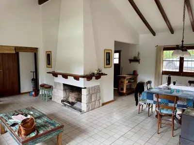 a living room with a fireplace and a table at Casa de Campo in Los Hornillos