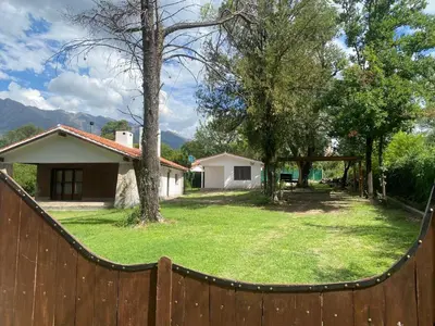 a fence in front of a yard with a house at Casa de Campo in Los Hornillos