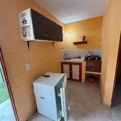 a small kitchen with a stove and a refrigerator at Complejo El Trencito in Villa Cura Brochero