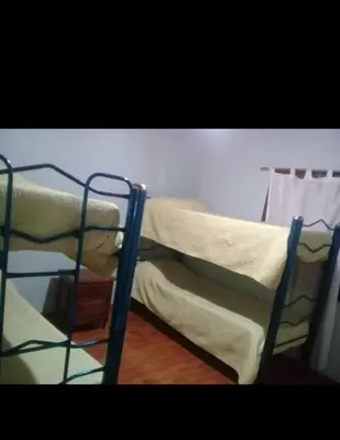 two bunk beds are in a room with a wall at Complejo El Trencito in Villa Cura Brochero