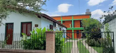 a house with a fence in front of it at Complejo El Trencito in Villa Cura Brochero