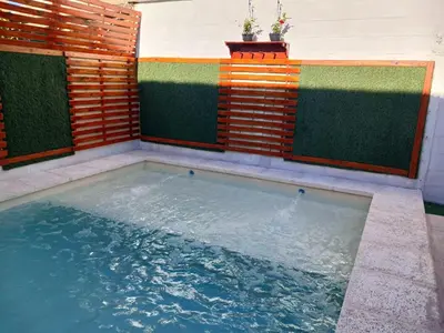 a pool of water in a backyard with a wooden fence at Complejo El Trencito in Villa Cura Brochero