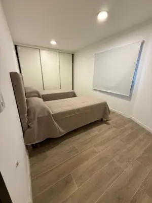a bedroom with a bed and a white wall at depto carlos paz in Villa Carlos Paz
