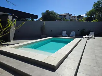 a swimming pool on a patio with two chairs next to it at depto carlos paz in Villa Carlos Paz