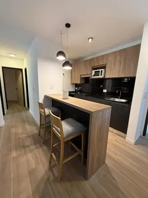 a kitchen with a island with chairs and a counter top at depto carlos paz in Villa Carlos Paz