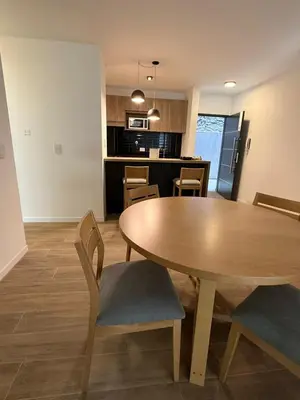 a dining room and kitchen with a wooden table and chairs at depto carlos paz in Villa Carlos Paz