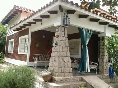 a house with a porch with two chairs and a stone pillar at 
