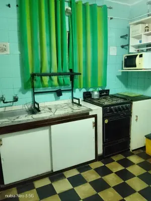 a kitchen with a stove and green curtains in it at 