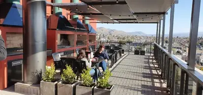 two women sitting on a balcony of a building at Departamento Edificio Leonardo 1 in Villa Carlos Paz