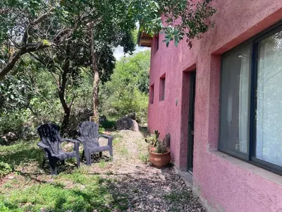 two chairs sitting outside of a pink building at CasaMonte in San Javier