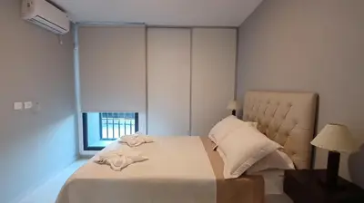 a bedroom with a large white bed and a window at Mi Espacio Departamento en Alta Gracia in Alta Gracia