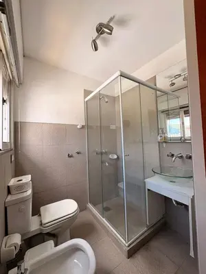 a bathroom with a toilet and a glass shower at Departamento 8 Villa Carlos Paz in Villa Carlos Paz