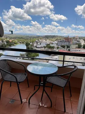 a table and chairs on a balcony with a view at Departamento 8 Villa Carlos Paz in Villa Carlos Paz