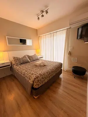 a bedroom with a bed and a desk and a television at Departamento 8 Villa Carlos Paz in Villa Carlos Paz