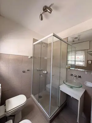a bathroom with a glass shower with a toilet and a sink at Departamento 8 Villa Carlos Paz in Villa Carlos Paz
