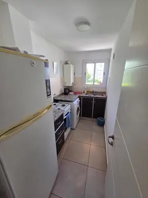 a kitchen with a white refrigerator and a stove at Depto Completo 1 Hab Gral Paz in Cordoba