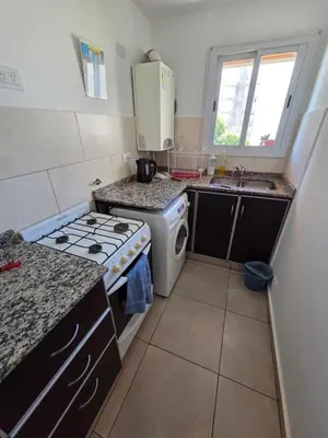 a small kitchen with a stove and a sink at Depto Completo 1 Hab Gral Paz in Cordoba