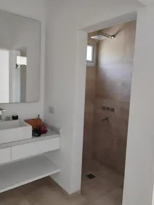 a bathroom with a sink and a shower at departamento en Lago Los Molinos in Villa Ciudad de America