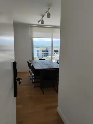 a dining room with a table and a large window at departamento en Lago Los Molinos in Villa Ciudad de America