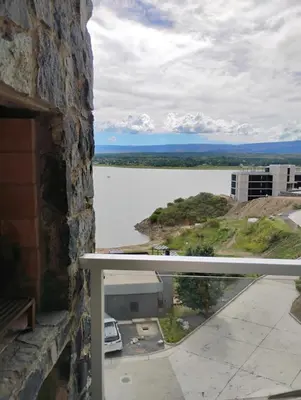 a view of a lake from the balcony of a building at departamento en Lago Los Molinos in Villa Ciudad de America