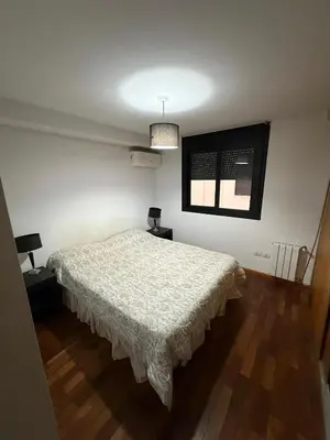a bedroom with a white bed and a window at Thays Apartment in Cordoba