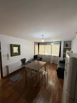 a kitchen and living room with a table and chairs at Thays Apartment in Cordoba