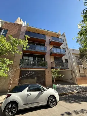 a white car parked in front of a building at Thays Apartment in Cordoba
