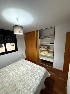 a bedroom with a bed and an open closet at Thays Apartment in Cordoba