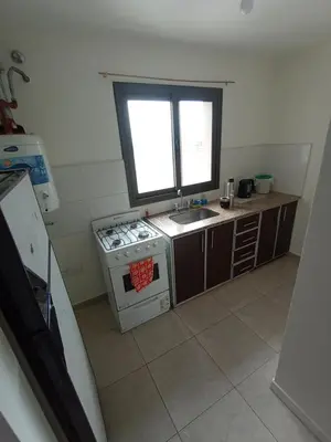 a kitchen with a stove and a sink and a window at Home Rio Cuarto 