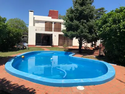 a large blue swimming pool in front of a house at Casa en Villa del dique con piscina ideal p dos familias in Villa del Dique