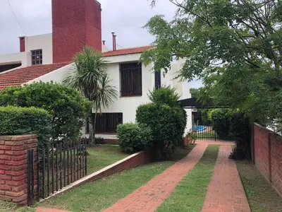 a house with a fence and a brick driveway at Casa en Villa del dique con piscina ideal p dos familias in Villa del Dique