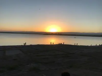 a group of people on the beach at sunset at Casa en Villa del dique con piscina ideal p dos familias in Villa del Dique