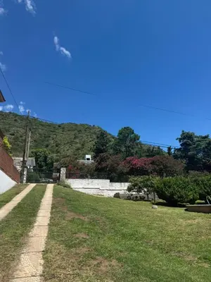 a path in a yard with a mountain in the background at Patio Serrano - Casa privada en planta baja in Villa Carlos Paz