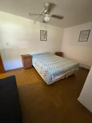 a bedroom with a bed and a ceiling fan at Patio Serrano - Casa privada en planta baja in Villa Carlos Paz