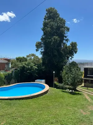 a large blue swimming pool in a yard at Patio Serrano - Casa privada en planta baja in Villa Carlos Paz