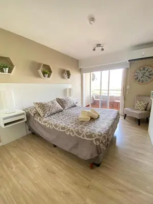 a bedroom with a bed with a clock on the wall at Departamento 3 centro villa carlos paz in Villa Carlos Paz