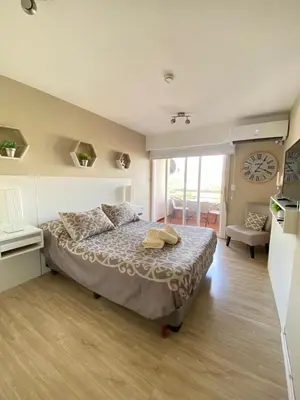 a bedroom with a bed with a clock on the wall at Departamento 3 centro villa carlos paz in Villa Carlos Paz