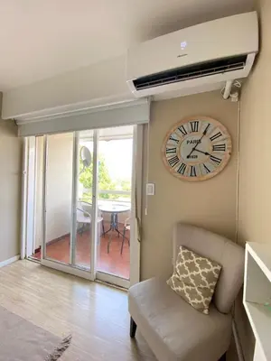 a large clock on the wall of a living room at Departamento 3 centro villa carlos paz in Villa Carlos Paz