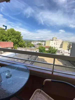 a table and chairs on a balcony with a view of a city at Departamento 3 centro villa carlos paz in Villa Carlos Paz