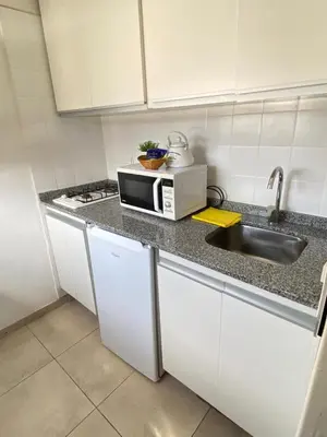 a kitchen with a sink and a microwave at Departamento 3 centro villa carlos paz in Villa Carlos Paz