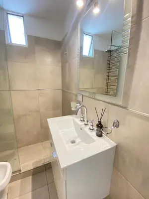 a white bathroom with a sink and a mirror at Departamento 3 centro villa carlos paz in Villa Carlos Paz