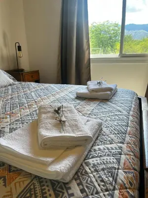 a bedroom with a bed with towels and a window at Altos de la Quebrada in Quebrada de los Pozos